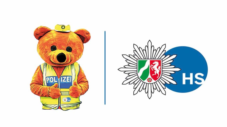 Links ist ein Bär mit einer Polizeiweste zu sehen. Rechts befindet sich das Logo der Polizei Heinsberg.